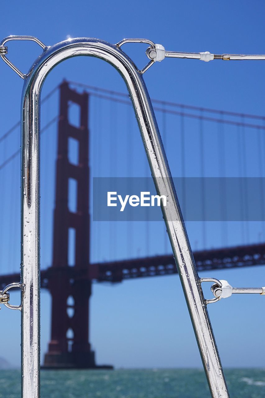 Close-up of boat railing with golden gate bridge in background