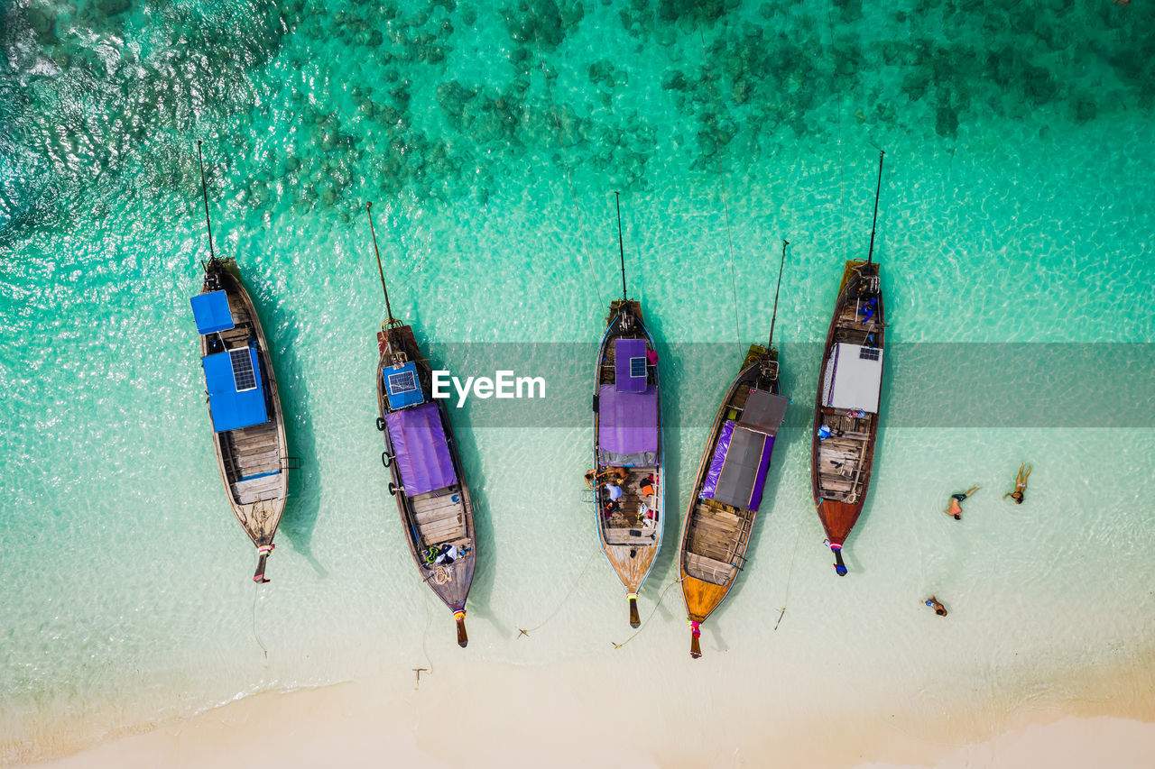 High angle view of longtail boats moored at shore of beach