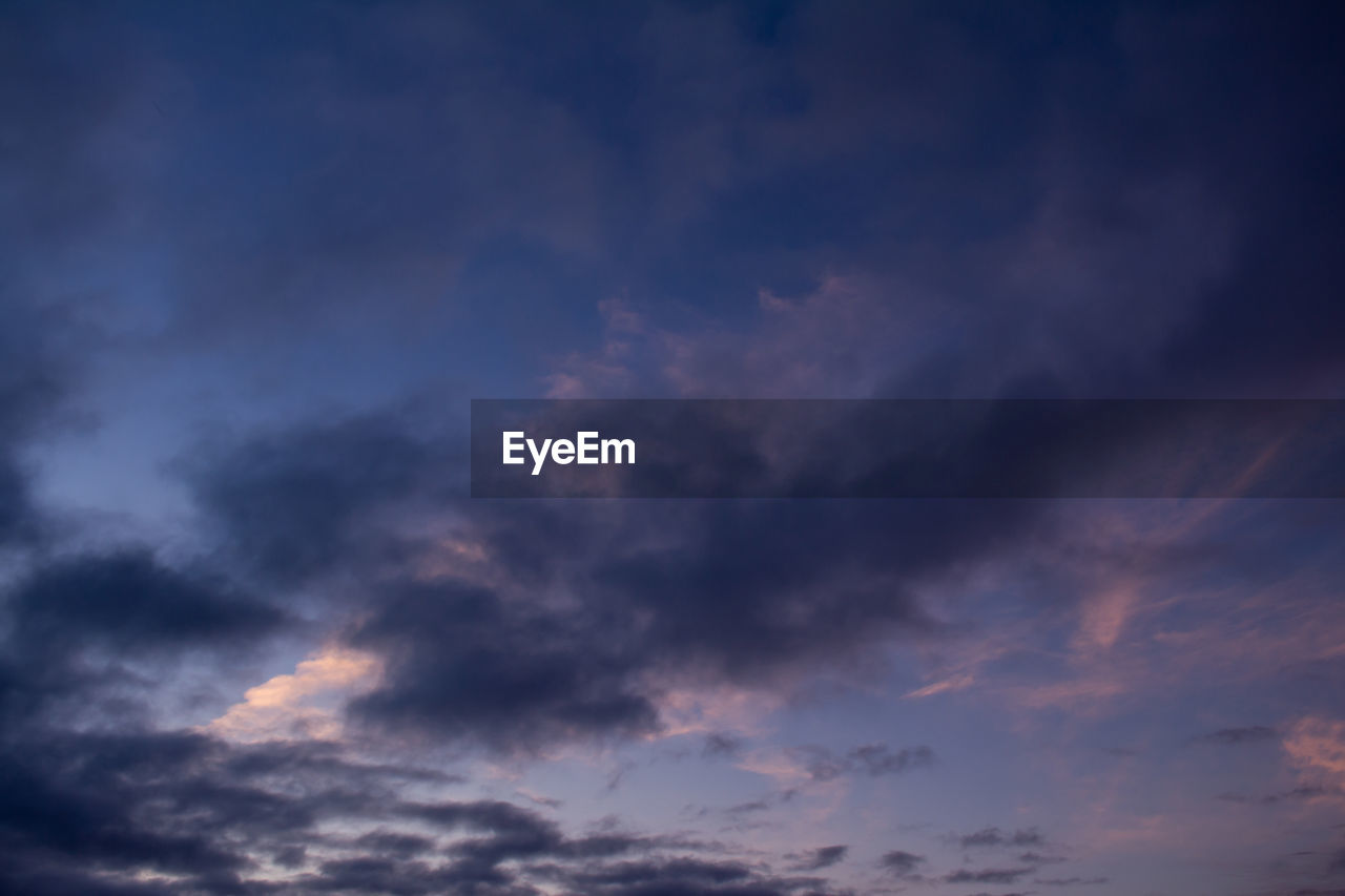 LOW ANGLE VIEW OF STORM CLOUDS IN SKY DURING SUNSET