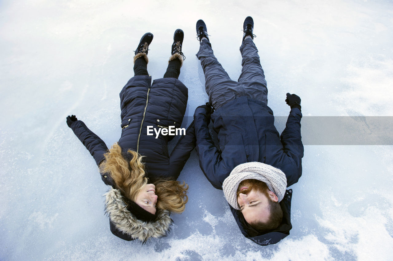 Couple lying on frozen lake