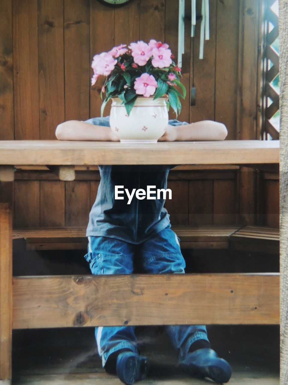 Boy behind vase on table