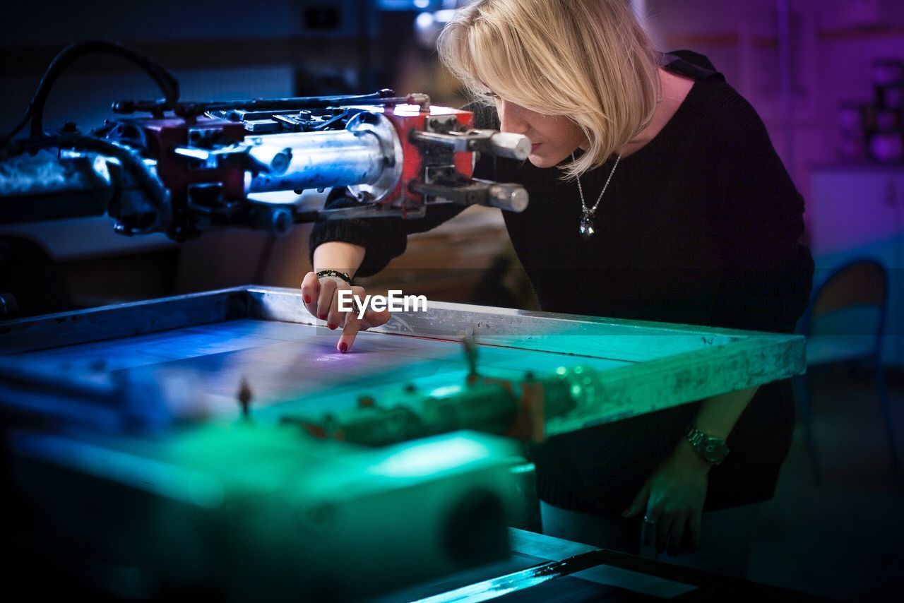 Businesswoman operating machinery at factory