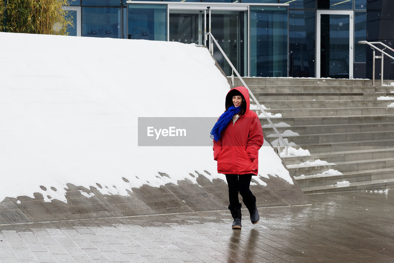 FULL LENGTH REAR VIEW OF WOMAN WALKING ON BUILDING