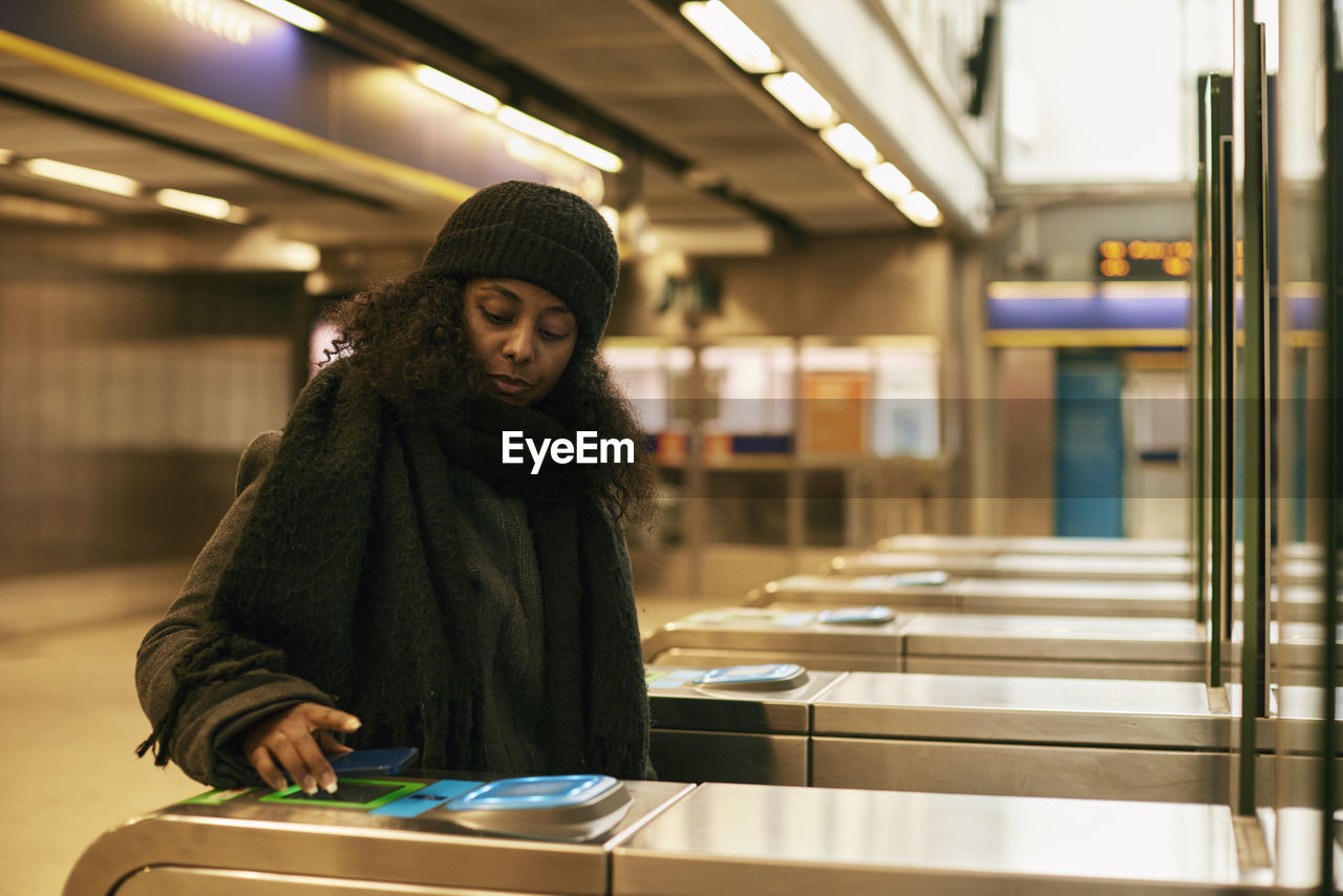 Woman paying for subway ticket with smart phone