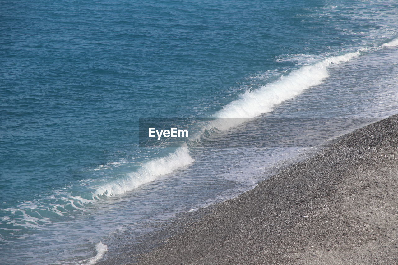 sea, water, wind wave, wave, beach, motion, shore, ocean, land, water sports, beauty in nature, sports, coast, surfing, day, scenics - nature, nature, high angle view, horizon, outdoors, body of water, sand, wave pattern, wind, wake, sunlight, tranquility, tranquil scene