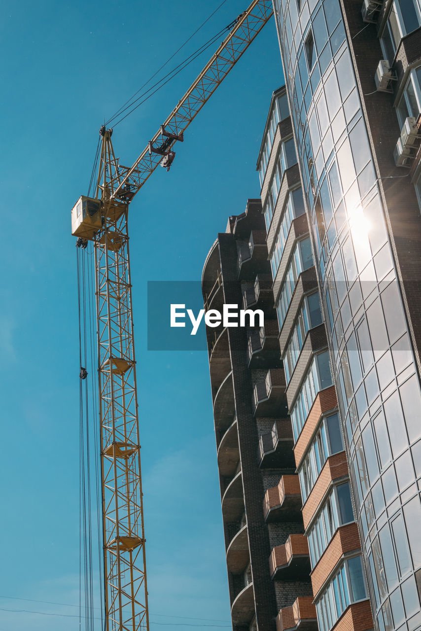 LOW ANGLE VIEW OF CRANE AGAINST SKY