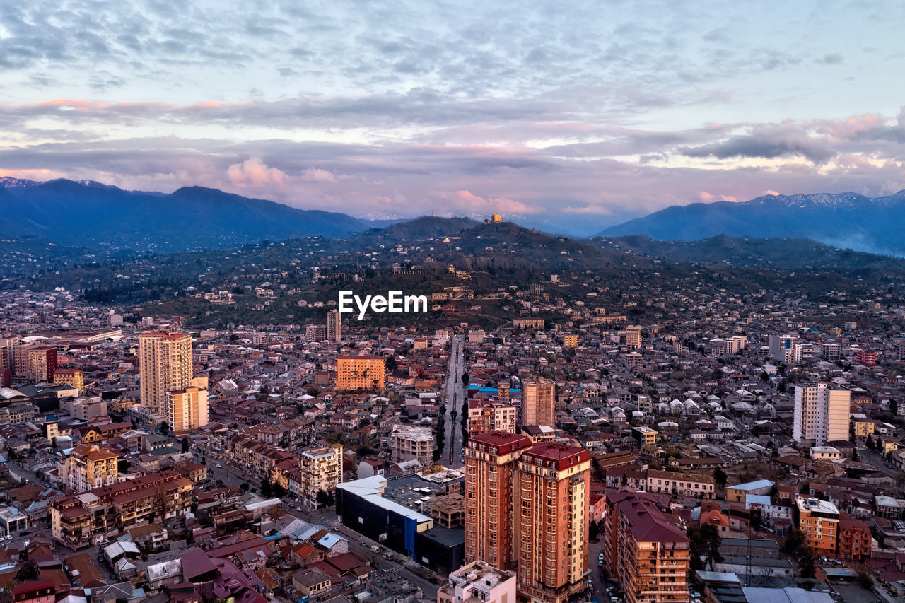 HIGH ANGLE VIEW OF ILLUMINATED CITY BUILDINGS AGAINST SKY