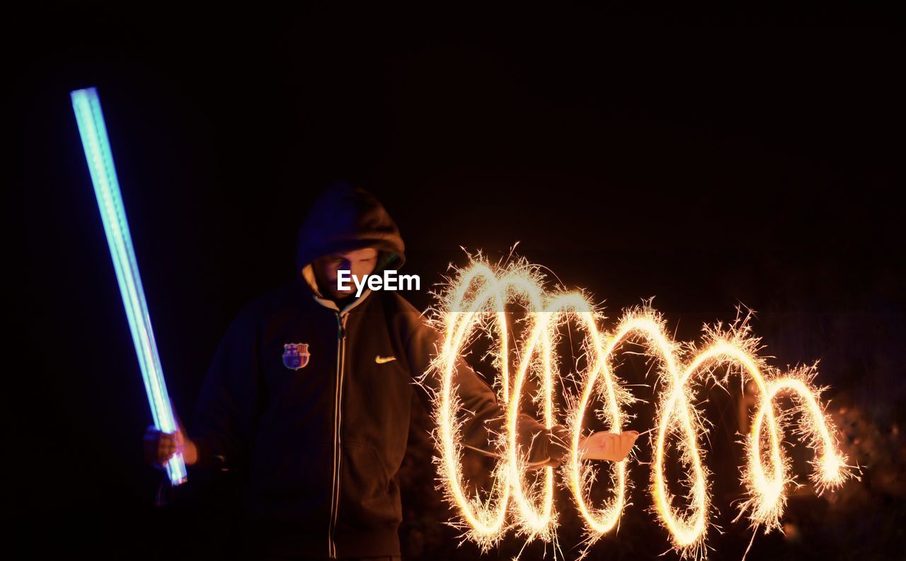 LOW ANGLE VIEW OF ILLUMINATED FIREWORK DISPLAY AT NIGHT