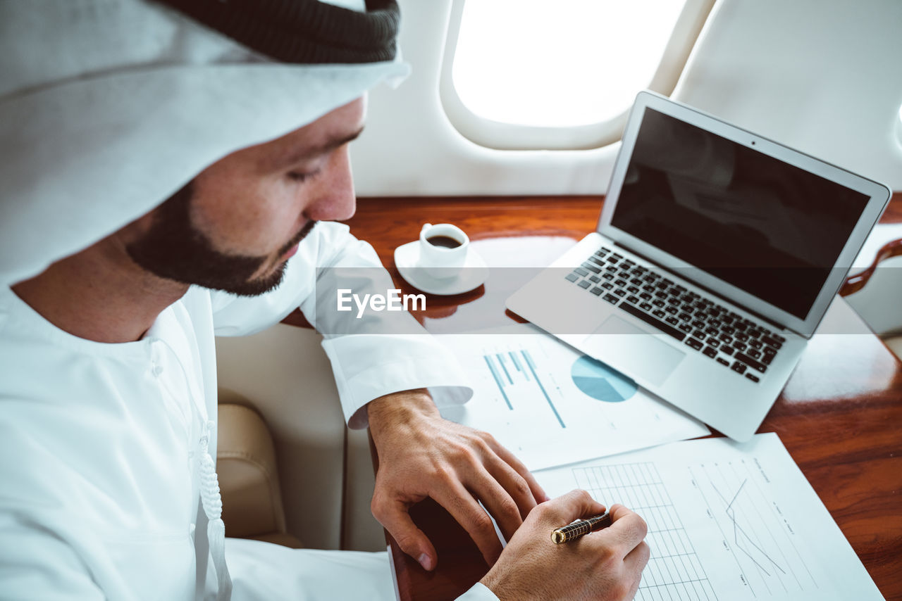 High angle view of businessman working in corporate jet