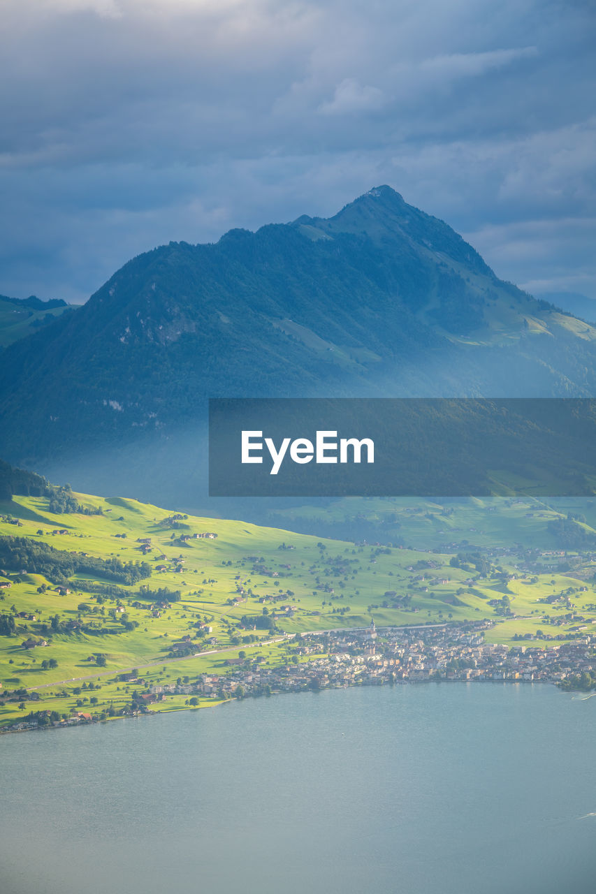 high angle view of city by mountains against sky