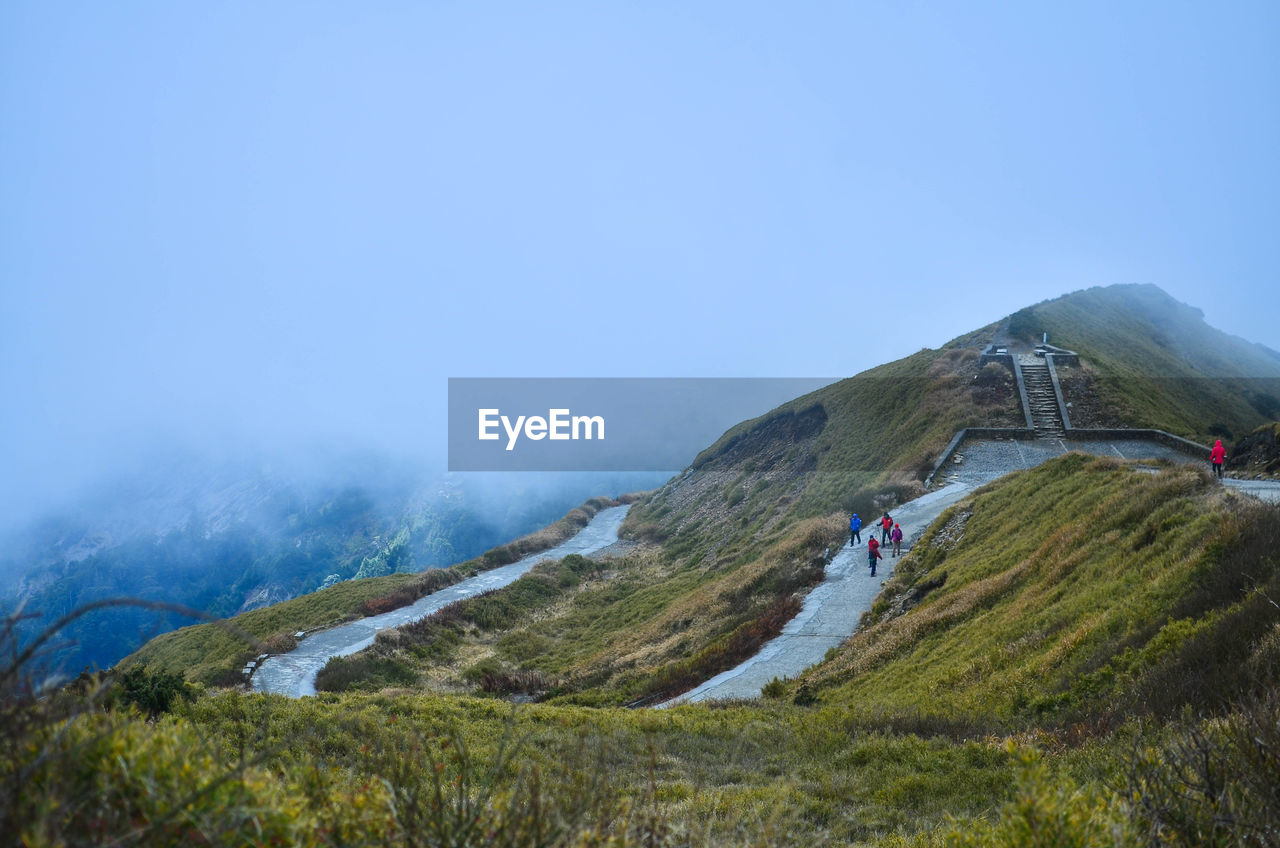 High angle view of hikers on mountain during foggy weather