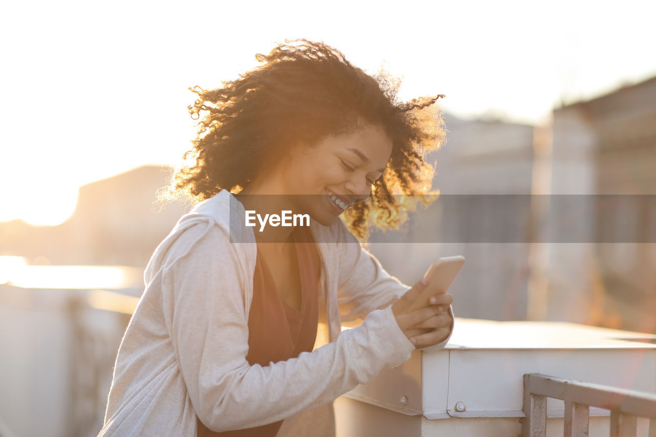 Young woman using mobile phone against white background