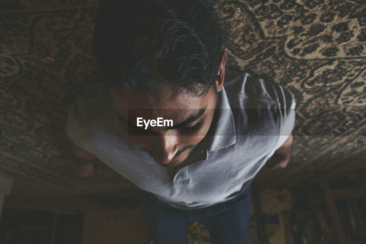 Upside down image of man resting on carpet at home