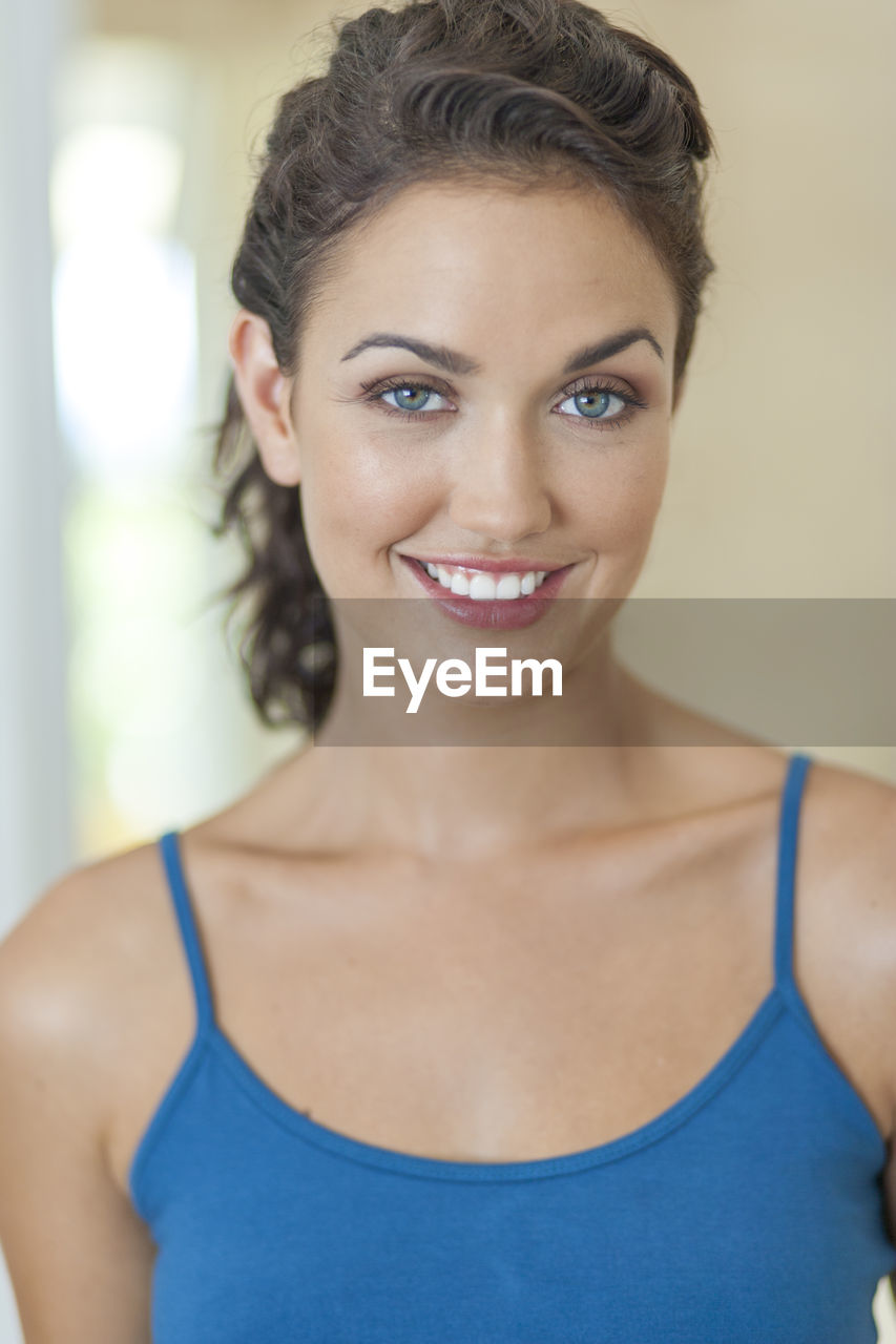 Portrait of smiling mid adult woman standing at home