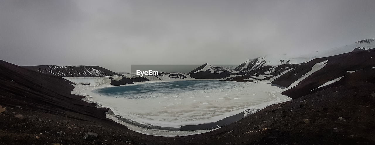 SCENIC VIEW OF SEA AND SNOWCAPPED MOUNTAIN AGAINST SKY