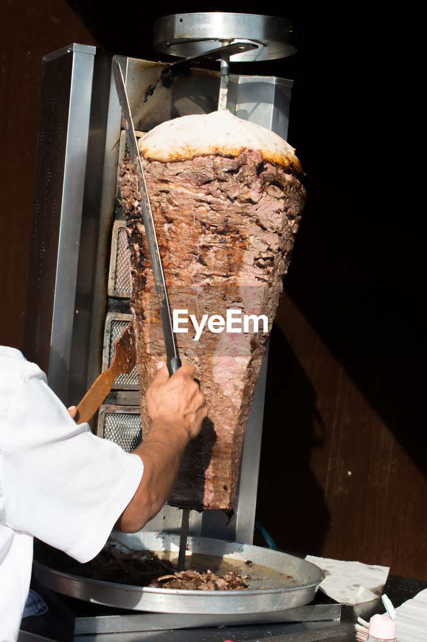 HAND HOLDING ICE CREAM IN RESTAURANT AT KITCHEN