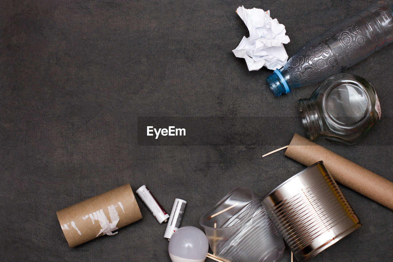 HIGH ANGLE VIEW OF BOTTLES ON TABLE AGAINST BLACK BACKGROUND