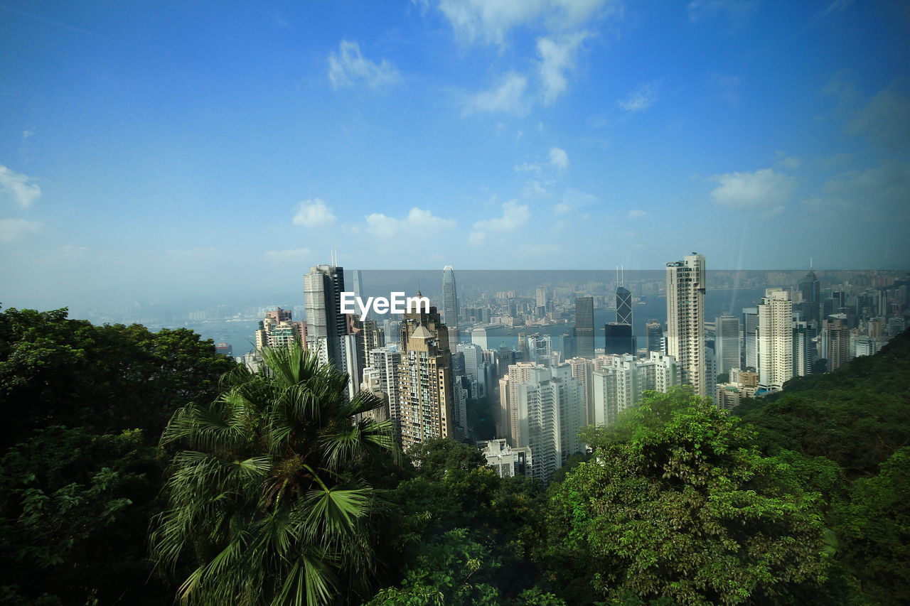 Panoramic view of trees and buildings against sky