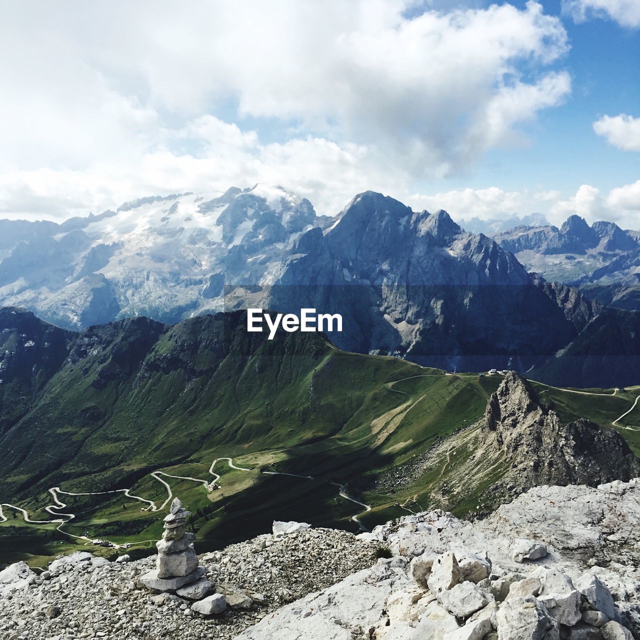 Stone cairn with road and mountains in background