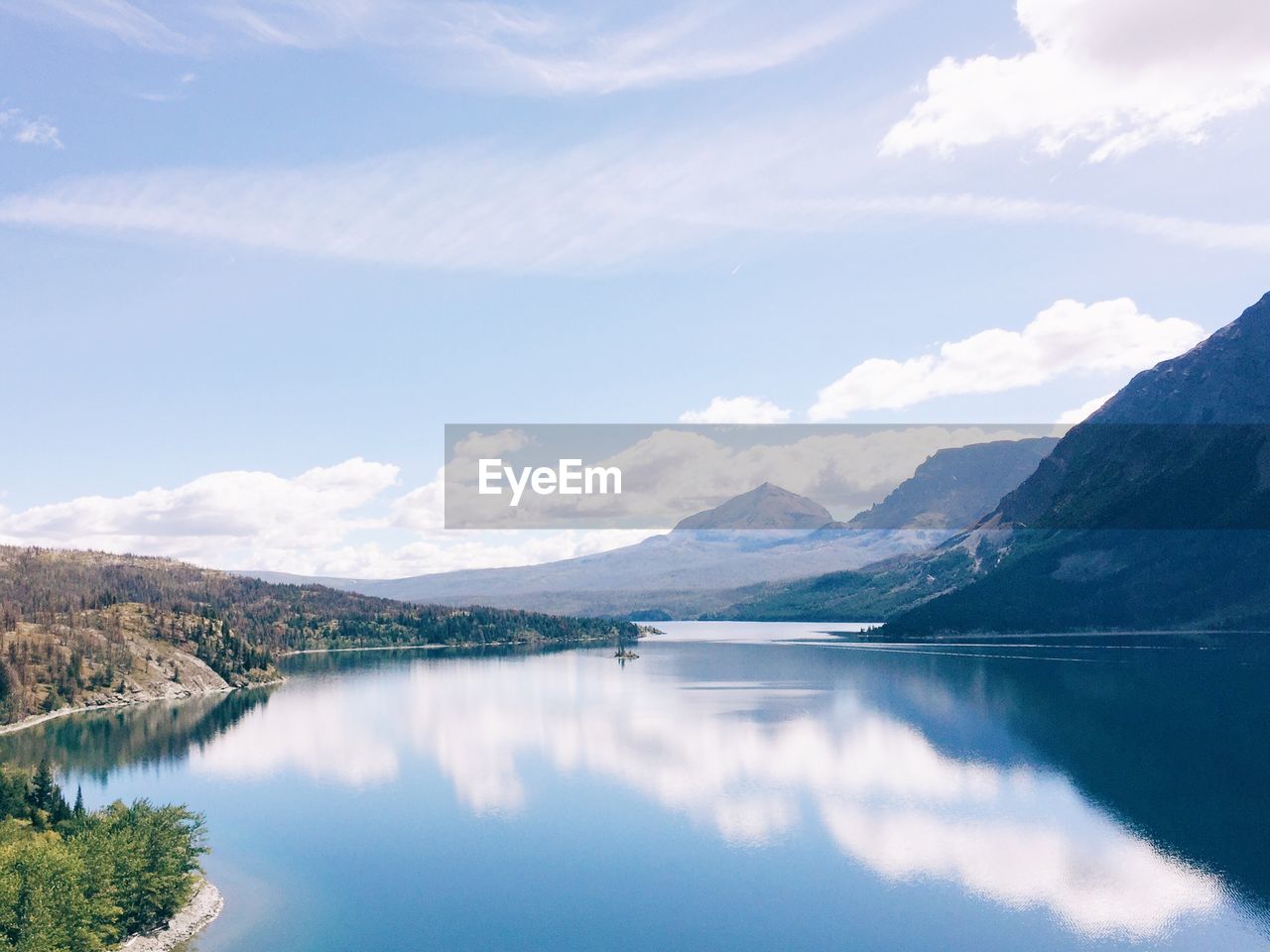 Scenic view of lake by mountains against sky