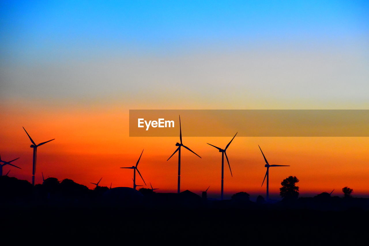 SILHOUETTE WINDMILLS ON FIELD AGAINST SKY DURING SUNSET