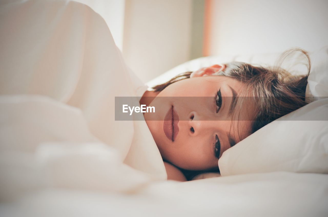 Close-up of woman lying on bed