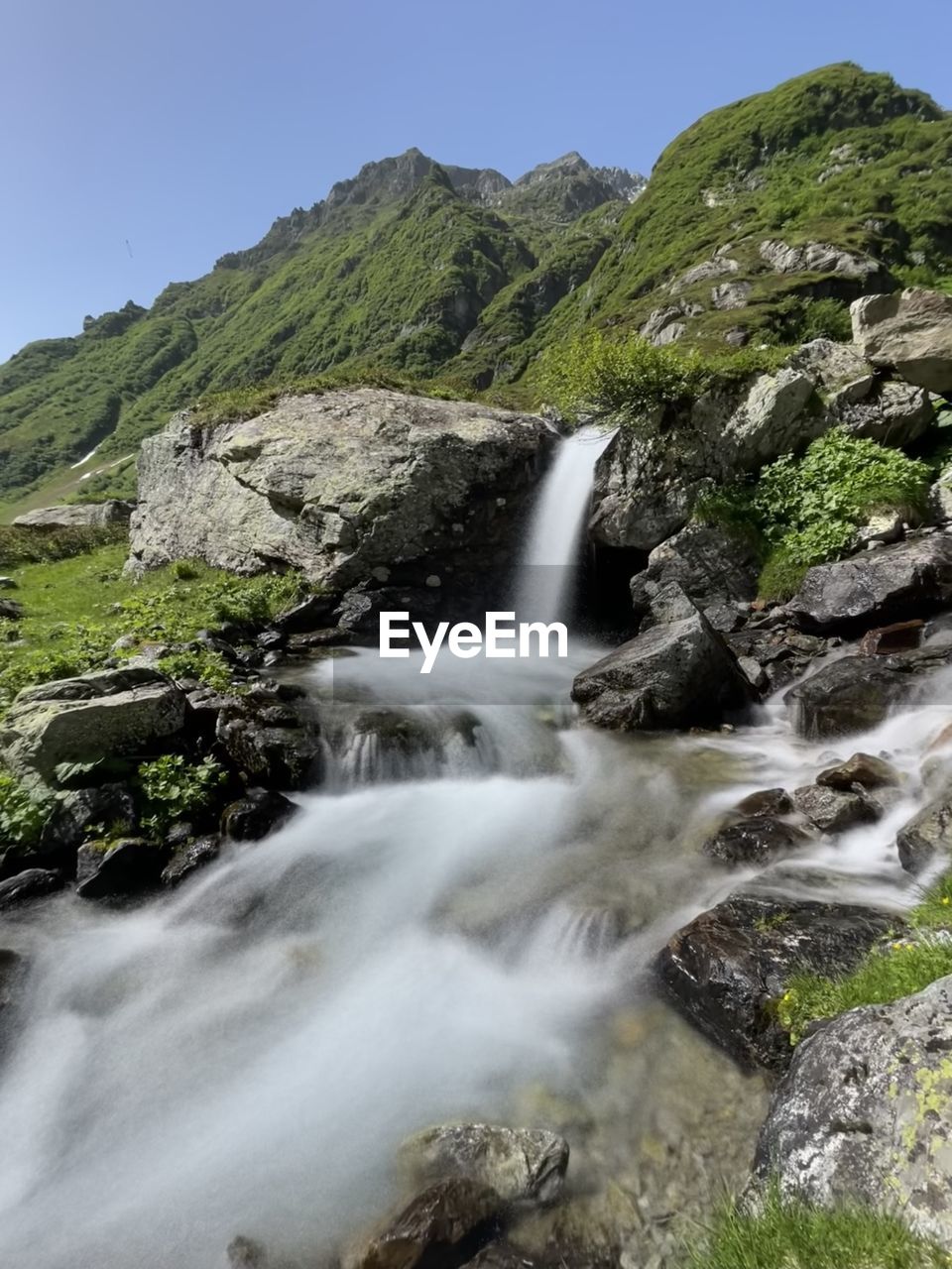 scenic view of waterfall against mountain