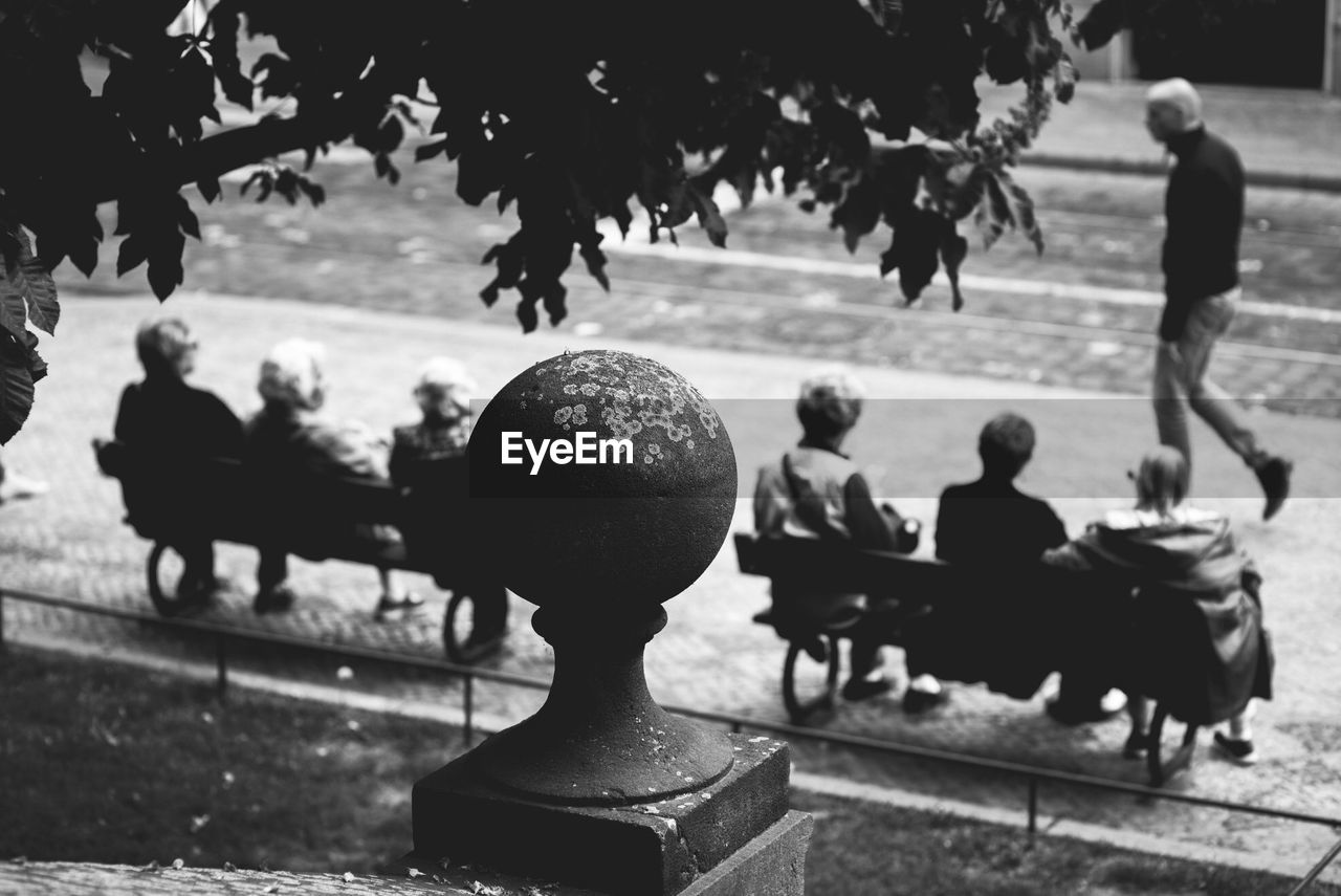 High angle view of friends sitting on benches in city