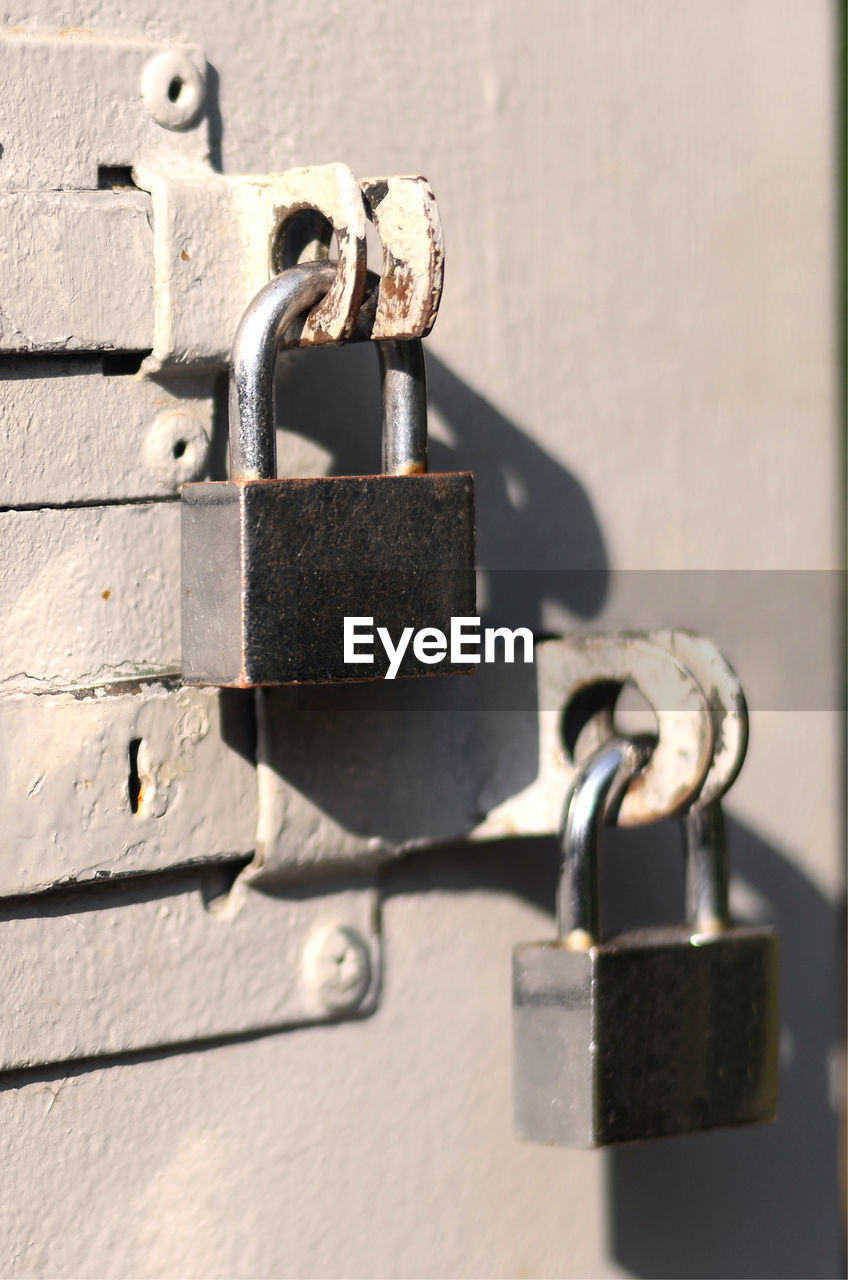 Close-up of padlocks hanging on metal door