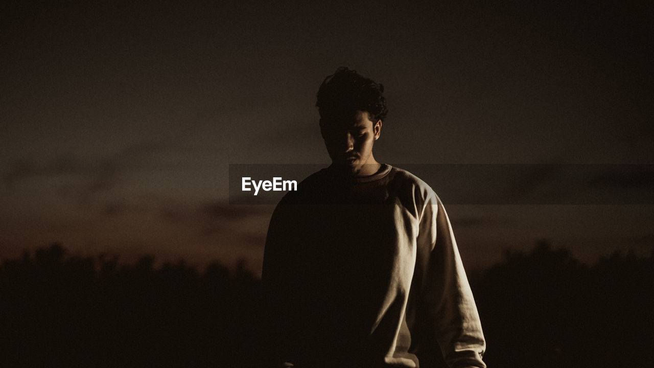 Thoughtful man walking against sky during dusk