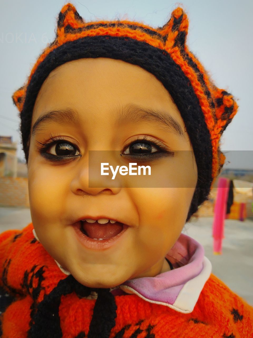 Close-up portrait of smiling boy against sky