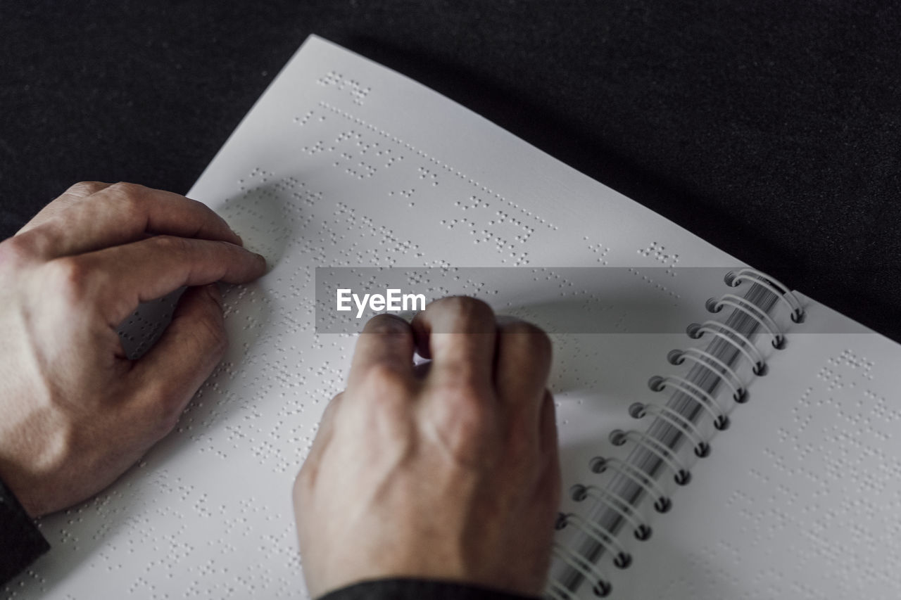 Man reading braille book