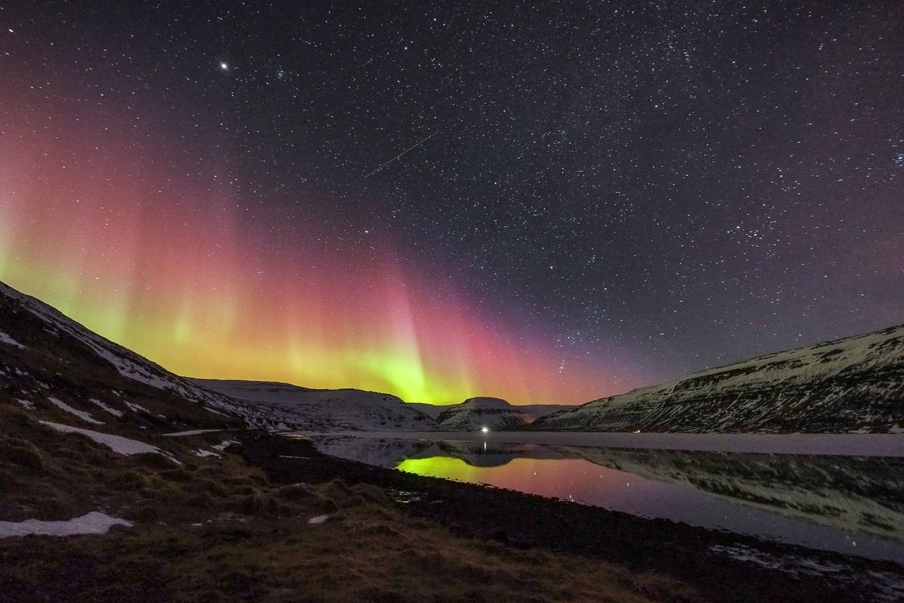 Aurora borealis on lake and landscape at night