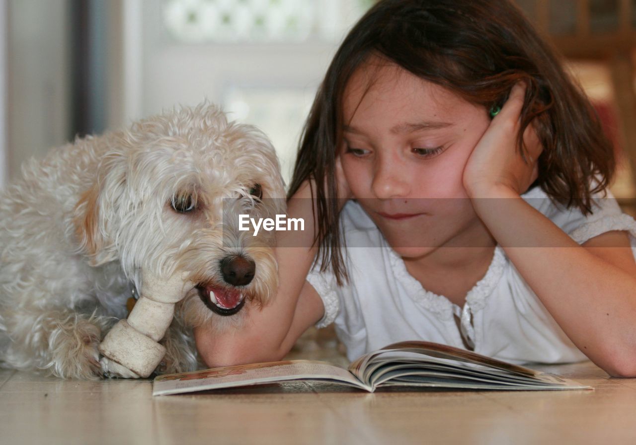 PORTRAIT OF CUTE GIRL WITH DOG IN MOUTH