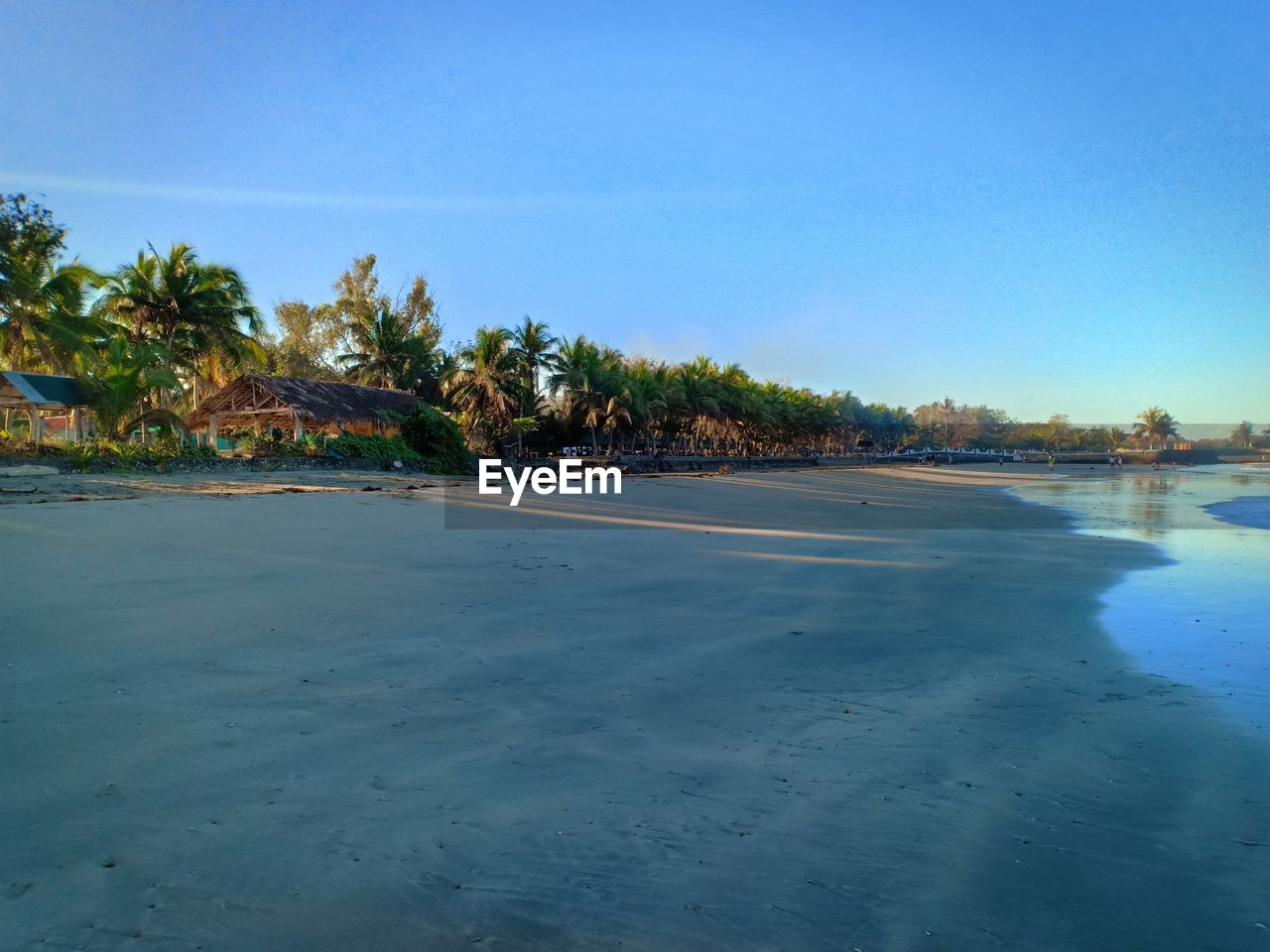 Scenic view of beach against clear blue sky