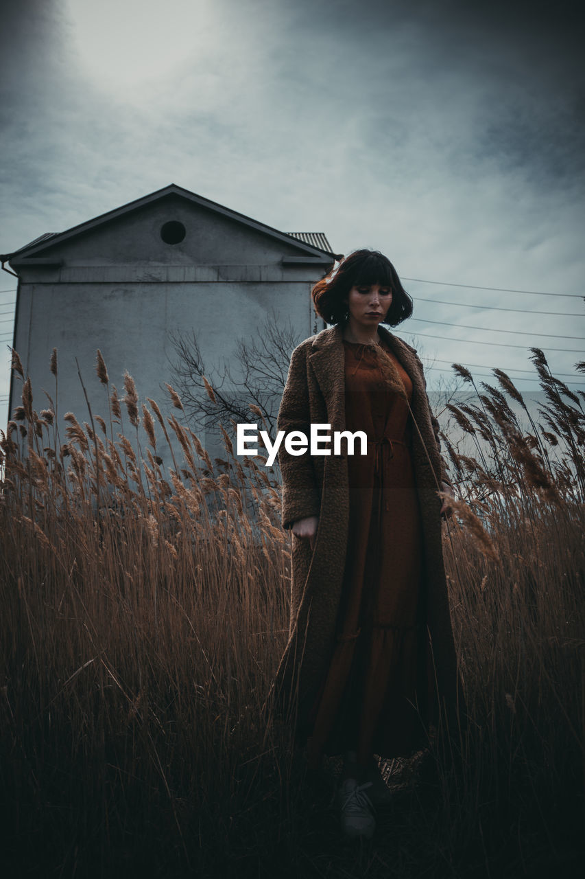 Woman standing on field against sky