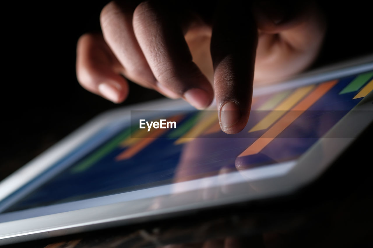 Close up of man hand analyzing chart on digital tablet