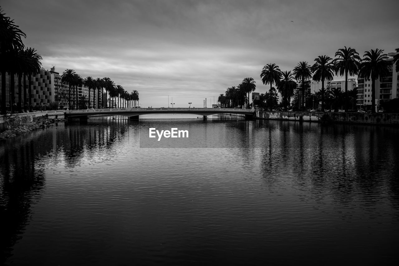 SCENIC VIEW OF RIVER BY CITY AGAINST SKY