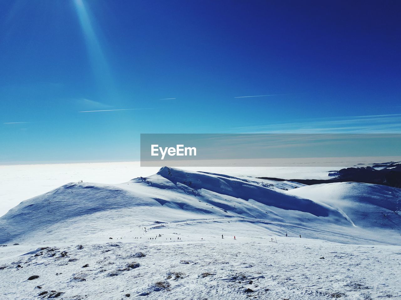 Scenic view of snowcapped mountain against blue sky