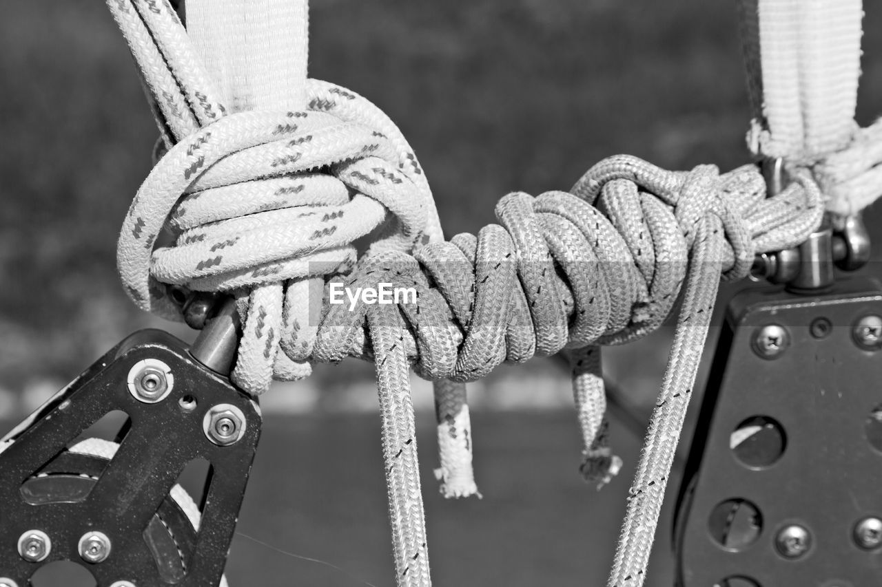 CLOSE-UP OF ROPE TIED UP ON METAL BOAT