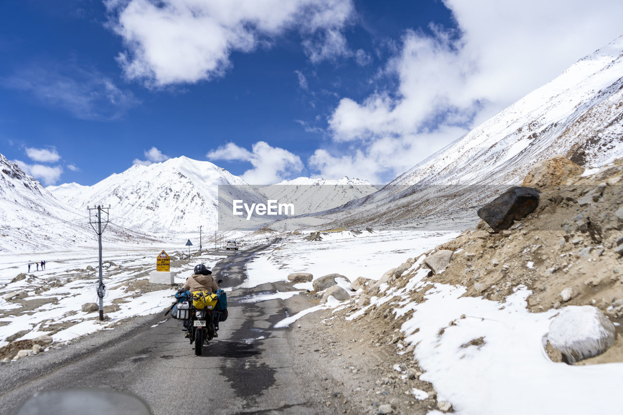 Indian biker riding a bike through the world highest motorable road khardungla pass in ladakh.