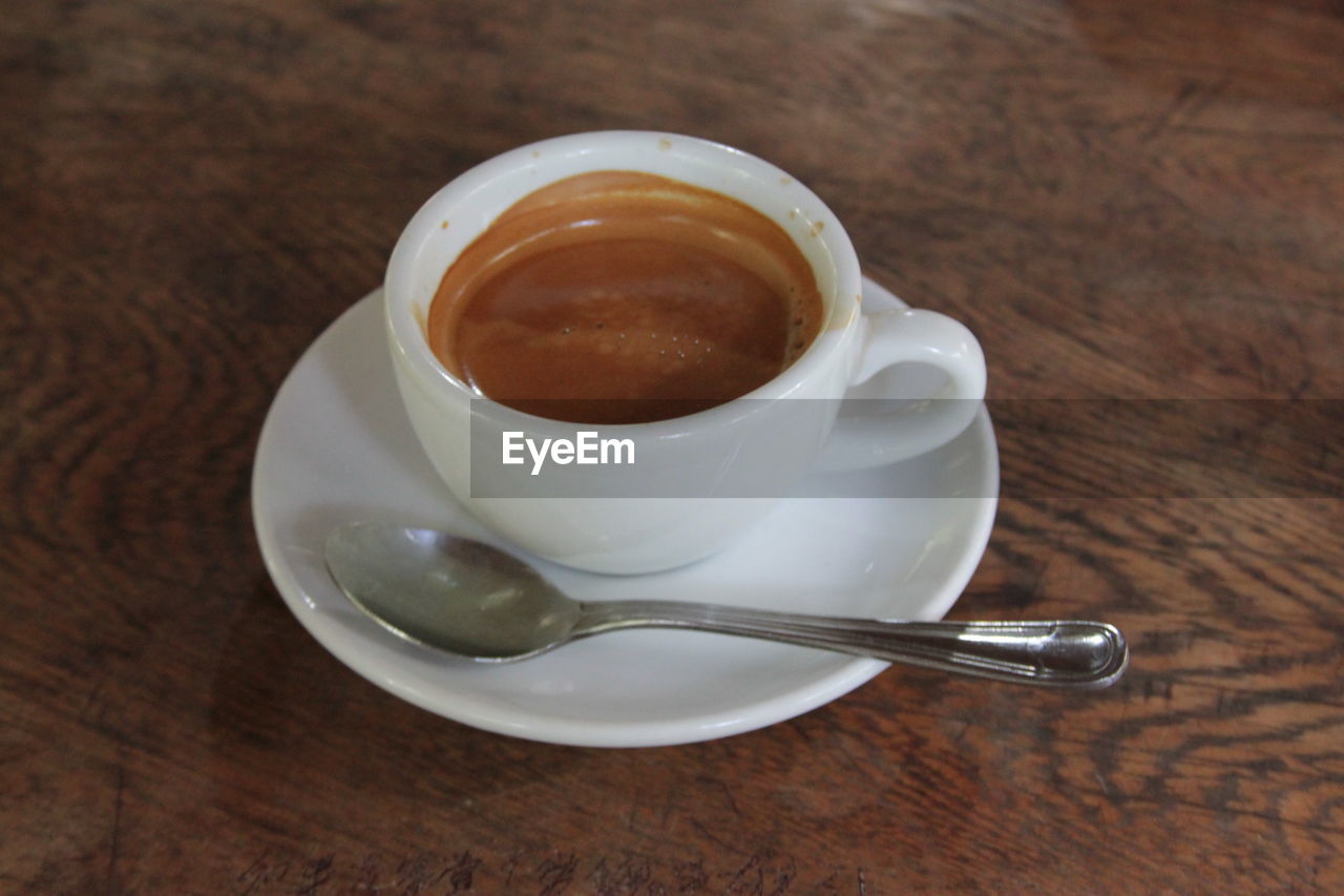 HIGH ANGLE VIEW OF COFFEE CUP WITH SPOON ON TABLE