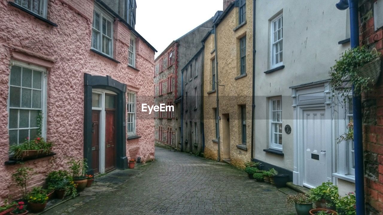 Street amidst houses against clear sky