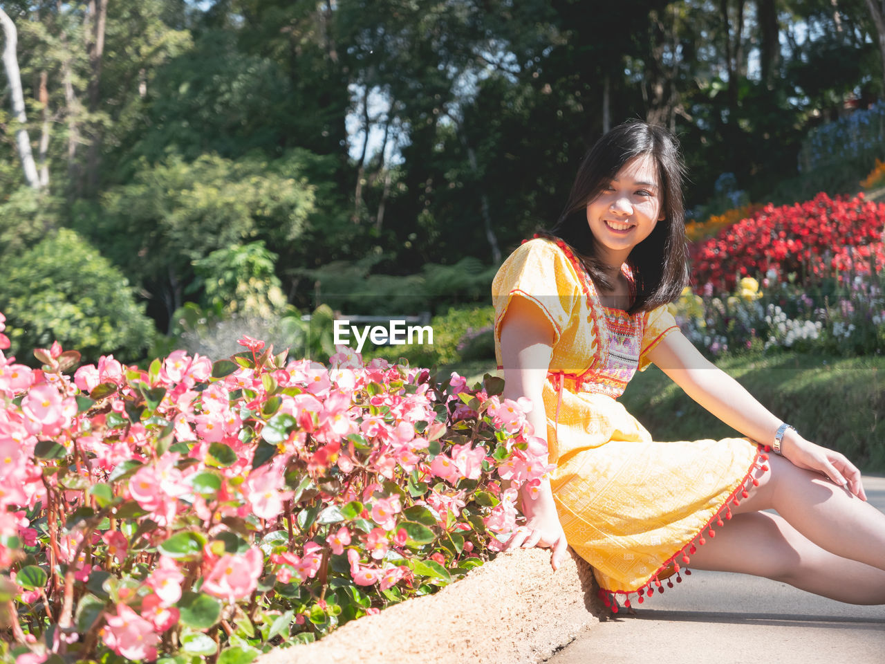 Side view of young woman sitting in park