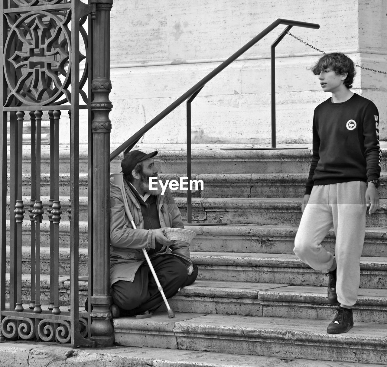 YOUNG COUPLE SITTING ON RAILING