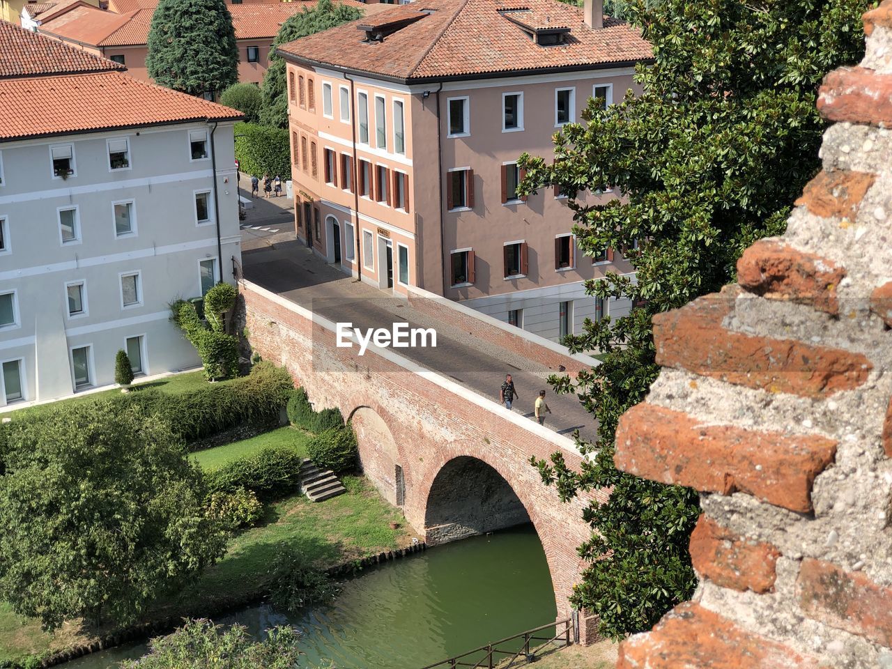 ARCH BRIDGE OVER RIVER AGAINST BUILDINGS