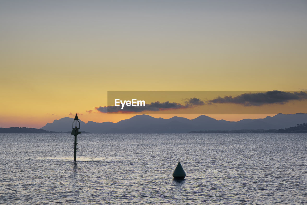 SILHOUETTE BOAT IN SEA AGAINST SKY AT SUNSET