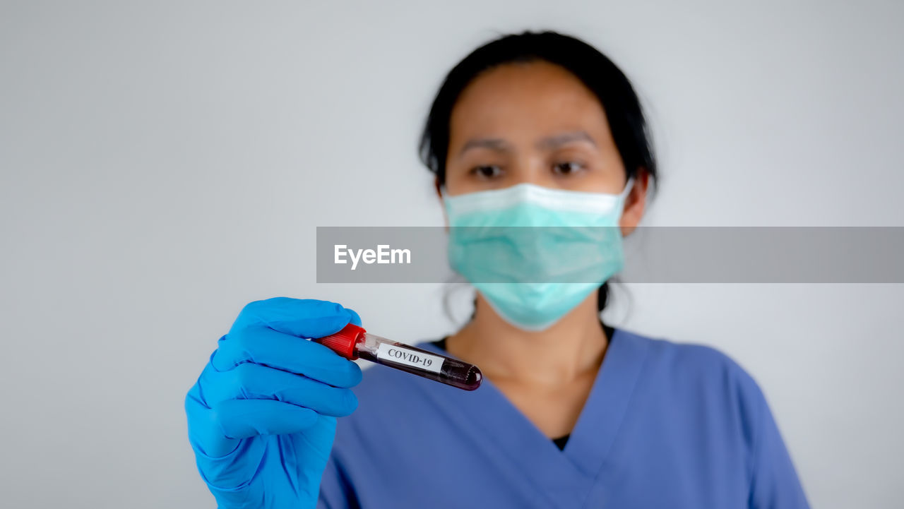 Doctor holding blood sample against white background