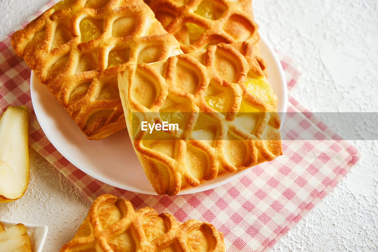 Puff pastry mini pies with with pear and lime jam filling on a white plate