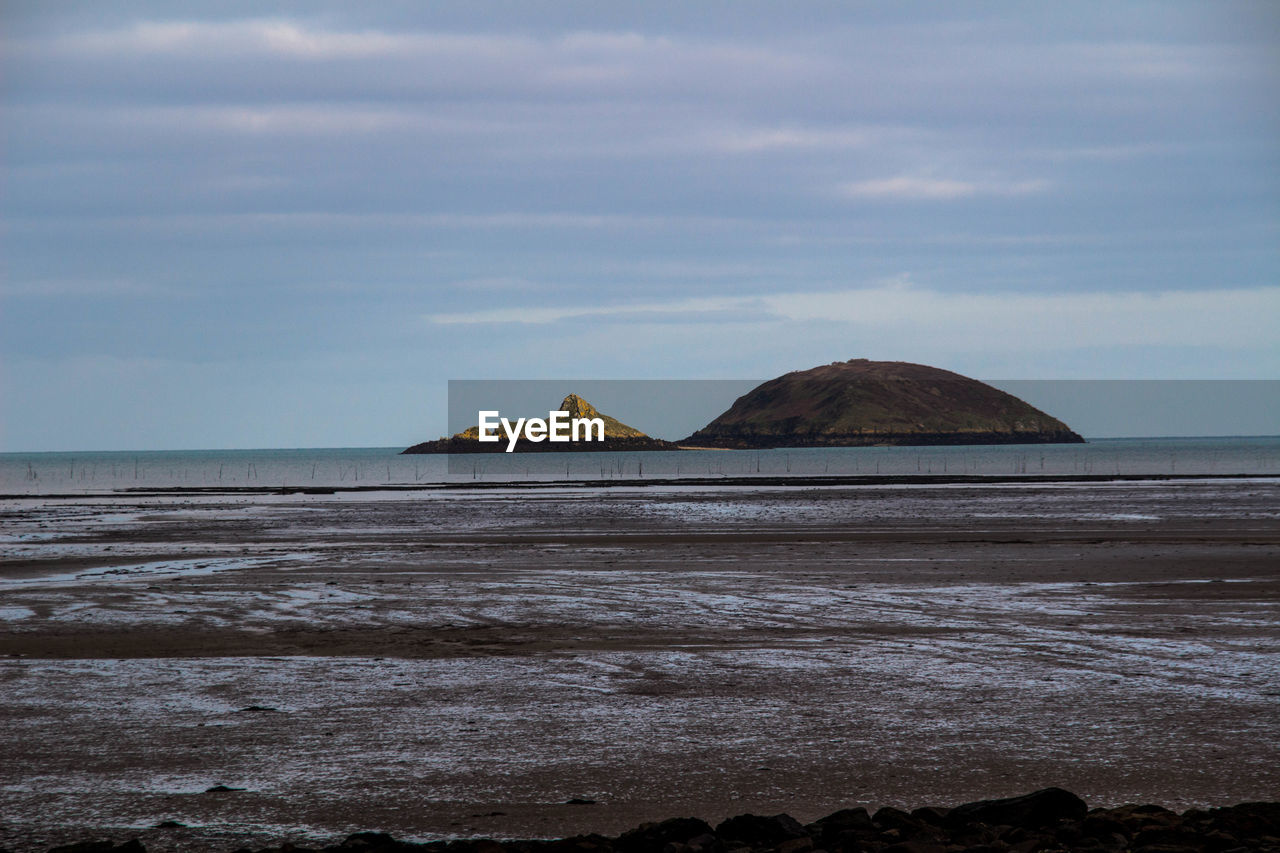 Scenic view of calm sea against cloudy sky